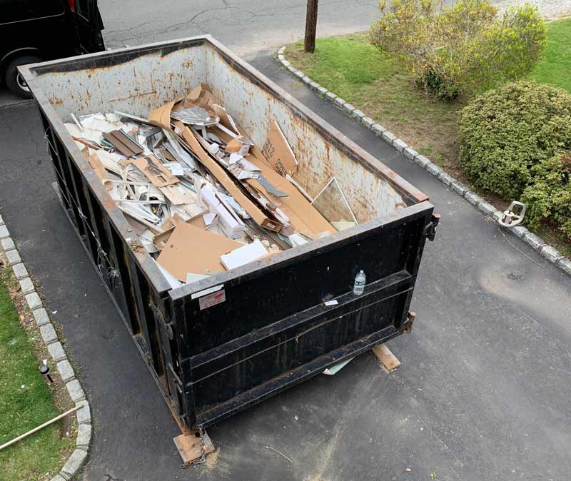 roll off dumpster with trash in it filled half way