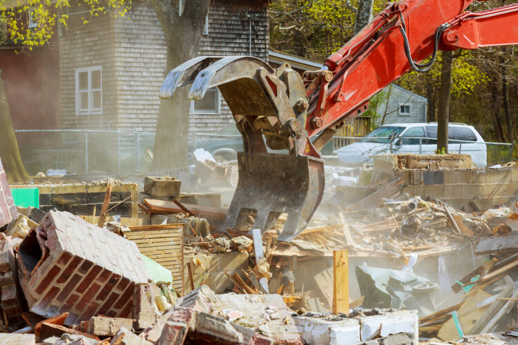 Demolition services of an old house, wooden planks and rubble and the ruins of the house for new construction project
